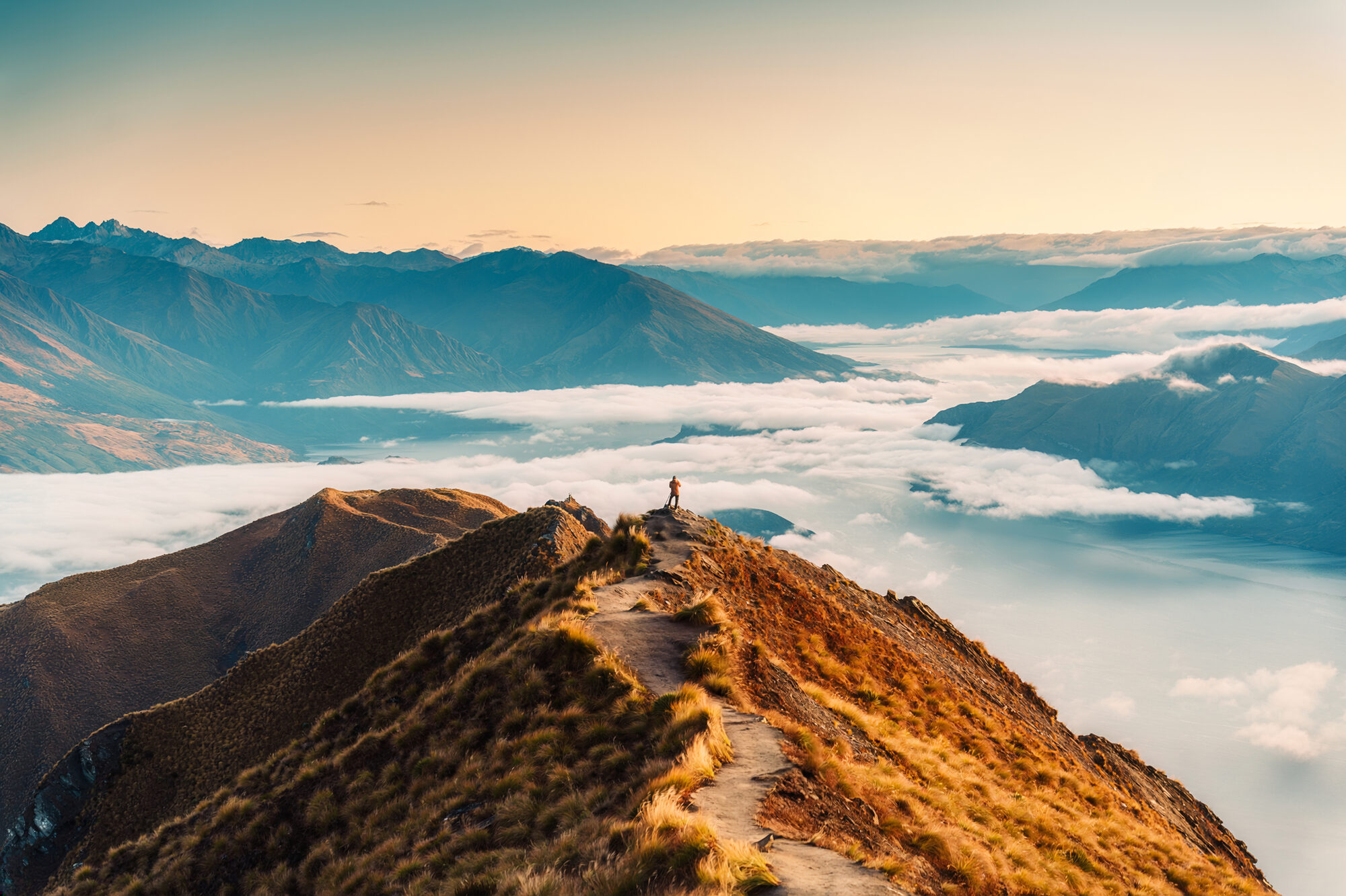 A mountain ridge above a sea of clouds at sunrise